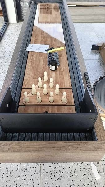 SHUFFLEBOARD TABLE (Category: Billiards and Bowling) located in San Pablo. Submitted by ablpsports (Listing ID 1460745529, Image 1). Description: - 2-in-1 Wooden Shuffleboard & Bowling Table - Includes 10 wooden pins, 4 pucks, and a brush - Smooth wooden playing surface - Sturdy wooden frame with black metal legs - Approximately 7-8 feet long - Ideal for family fun and game nights - Ready for pickup.