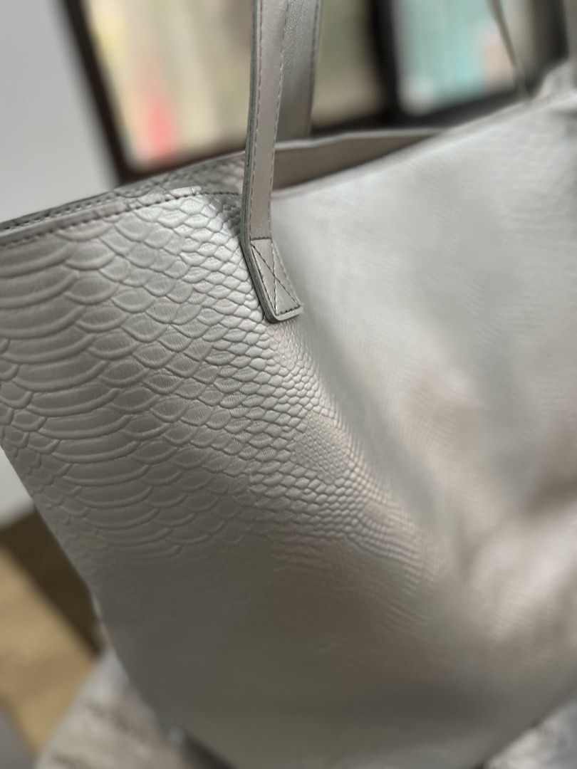 Silver Textured Tote Bag with Pouch (Category: Tote Bags) located in Quezon City. Submitted by happyshop31 (Listing ID 1460726728, Image 2). Description: - Chic silver tote bag - Unique snakeskin-like texture - Spacious interior - Comes with a navy blue inner pouch - Light grey handles - Ideal for everyday errands or travel - Unbranded.