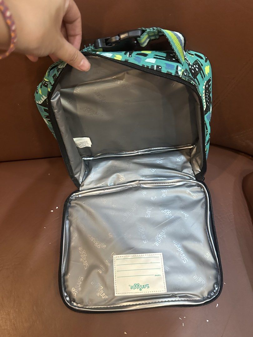 Smiggle Dinosaur Lunch Bag Teal (Category: Babies & Kids Fashion) located in Quezon City. Submitted by mthereser43807 (Listing ID 1460758628, Image 2). Description: - Fun Smiggle dinosaur lunch bag - Teal color with black & green accents - Insulated interior to keep food fresh - Includes an internal name tag - Ideal for school or day trips.