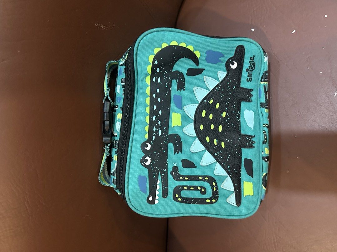 Smiggle Dinosaur Lunch Bag Teal (Category: Babies & Kids Fashion) located in Quezon City. Submitted by mthereser43807 (Listing ID 1460758628, Image 1). Description: - Fun Smiggle dinosaur lunch bag - Teal color with black & green accents - Insulated interior to keep food fresh - Includes an internal name tag - Ideal for school or day trips.