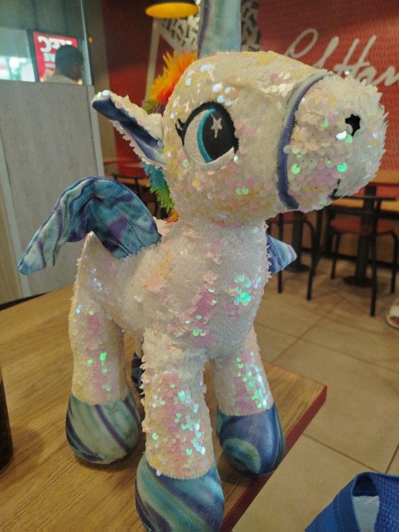 Sparkly Sequin Unicorn Plush Toy with Rainbow Mane (Category: Plushies & Soft Toys) located in Manila. Submitted by purediamond888 (Listing ID 1460796455, Image 1). Description: - Super cute sparkly unicorn plushie - Covered in iridescent sequins - Rainbow colored mane and tail - Blue and purple tie-dye wings - Ideal for kids or as a fun decoration.