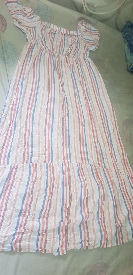 Striped Maxi Dress (Category: Dresses) located in Quezon City. Submitted by seventeenjeonghan (Listing ID 1460772151, Image 1). Description: - White maxi dress with pink and blue stripes - Off-the-shoulder design - Elasticated waist for a comfortable fit - Flowy and breezy fabric - Ideal for casual outings, beach days, or resort wear - Easy to style and wear.