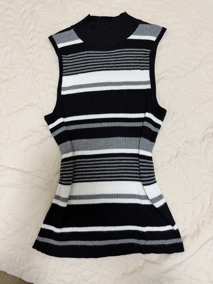 Striped Mock Neck Sleeveless Knit Top (Category: Sleeveless) located in Manila. Submitted by aickasomb14373 (Listing ID 1460803658, Image 1). Description: - Chic sleeveless top in black, white, and grey stripes - Stylish mock neck design - Comfortable ribbed knit material - Flattering fitted silhouette with a subtle flare at the hem - Versatile for pairing with jeans or skirts - Ideal for layering or wearing as a standalone piece.