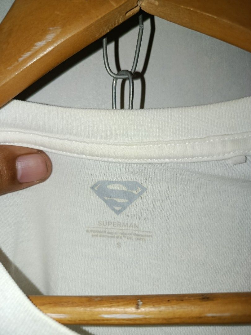 Superman Graphic T-Shirt (Category: Tshirts & Polo Shirts ) located in Nabunturan. Submitted by marmitoren42236 (Listing ID 1460871954, Image 2). Description: - White t-shirt with a cool, distressed red and blue Superman logo graphic. - 'SUPERMAN' text printed below the logo. - Tag shows size S. - Ideal for any Superman fan..