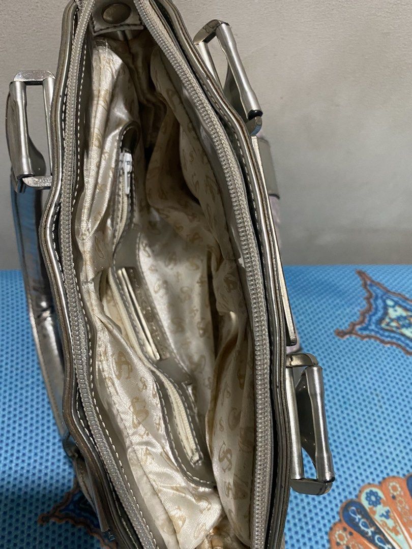 SWISH JEANS Silver Lilac Textured Handbag (Category: Shoulder Bags) located in Lucena. Submitted by mercie.banayo (Listing ID 1460865856, Image 3). Description: - Cute Swish Jeans handbag - Silver and lilac textured fabric - Metallic silver trim and handles - Zipper closure - Interior zip pocket and slip pockets - Metal studs on bottom for protection - Great for everyday use.