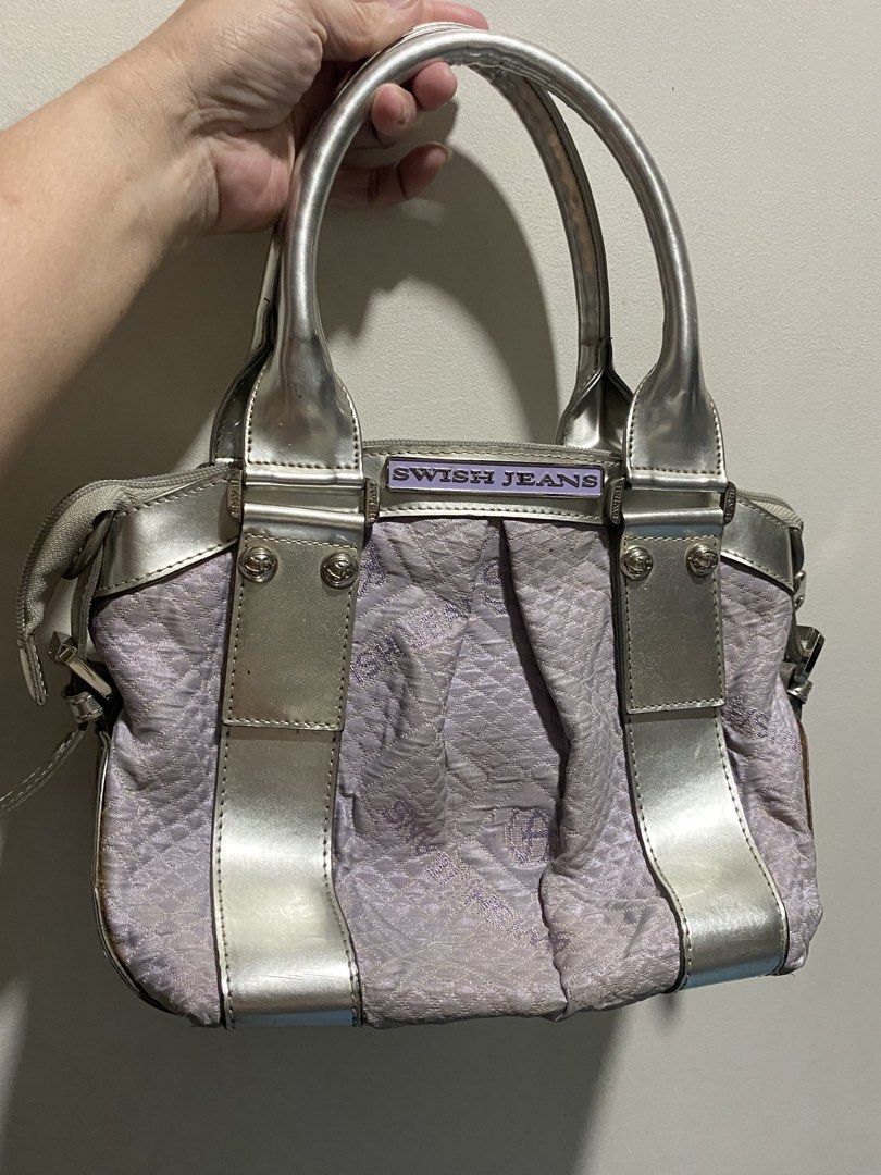SWISH JEANS Silver Lilac Textured Handbag (Category: Shoulder Bags) located in Lucena. Submitted by mercie.banayo (Listing ID 1460865856, Image 1). Description: - Cute Swish Jeans handbag - Silver and lilac textured fabric - Metallic silver trim and handles - Zipper closure - Interior zip pocket and slip pockets - Metal studs on bottom for protection - Great for everyday use.