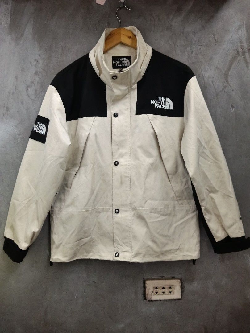 The North Face Jacket Beige Black Size M (Category: Coats, Jackets and Outerwear) located in Caloocan City. Submitted by arielagost83627 (Listing ID 1460800272, Image 1). Description: - Brand: The North Face - Color: Beige and Black - Size: Medium (M) - Features: Classic North Face logo on chest, back, and left sleeve patch - Design: Button-up front with a high collar - Ideal for: Outdoor activities and casual wear Color Rate: 9.5/10 Dimes: 22x26