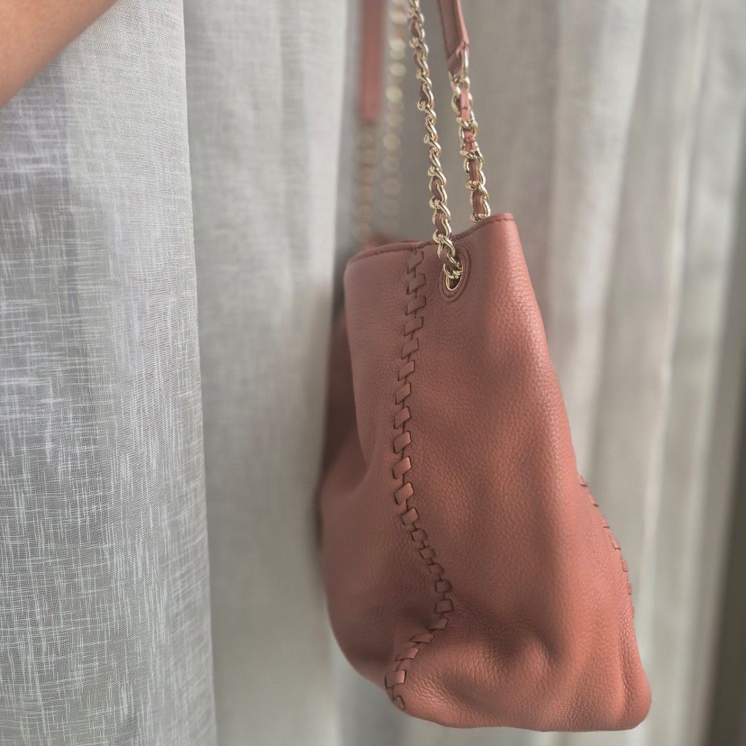 Tory Burch Leather Tote Bag with Chain Strap (Category: Luxury Bags & Wallets) located in Quezon City. Submitted by prelovedluxury21 (Listing ID 1460765741, Image 2). Description: - Salmon pink leather Tory Burch tote bag - Features braided stitch detail along edges - Gold chain strap - Iconic Tory Burch logo embossed on front - Spacious interior, perfect for everyday use - Shows some signs of wear on leather and hardware.