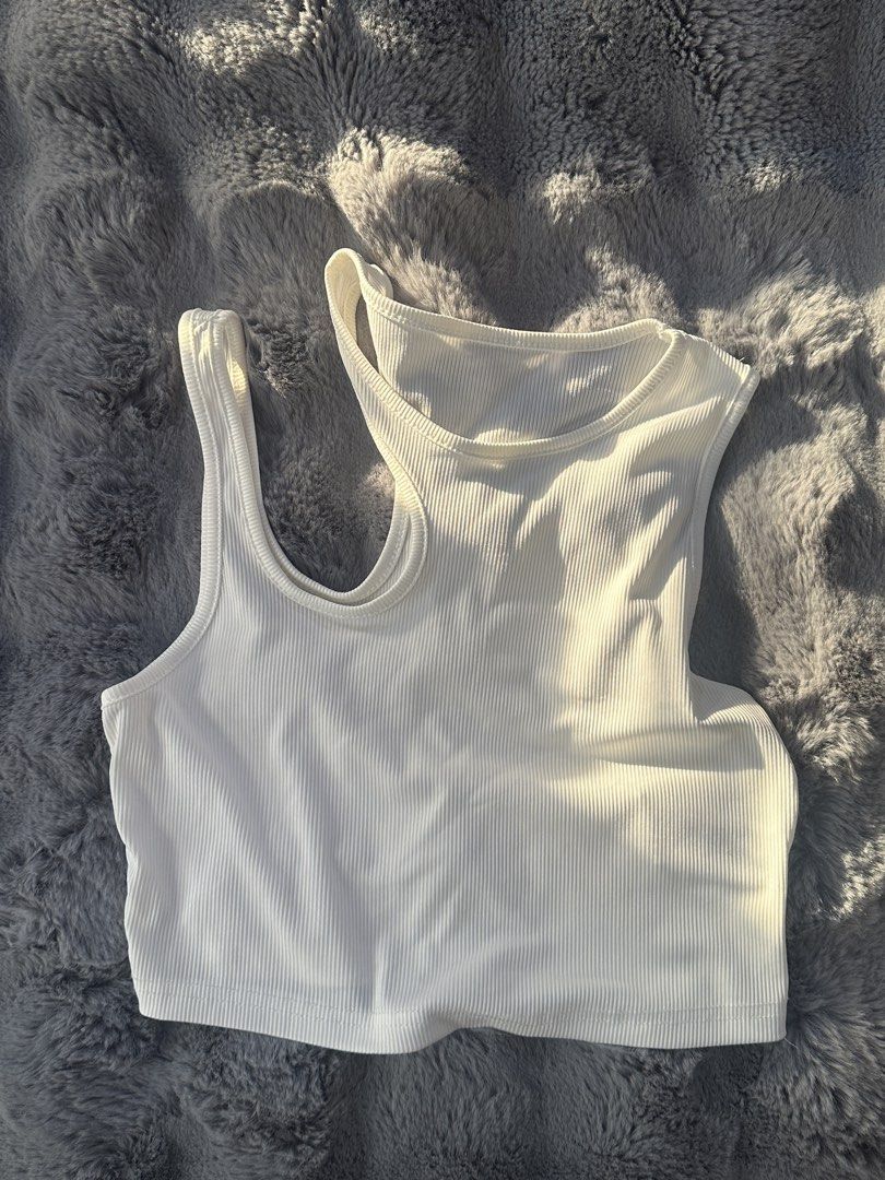 White Ribbed Cropped Tank Top (Category: Sleeveless) located in Valenzuela. Submitted by mar1ascloset_ (Listing ID 1460894112, Image 1). Description: - S-L - White ribbed cropped tank top - Sleeveless with racerback design - Stretchy and comfortable material - Ideal for layering or wearing alone - Versatile: pairs well with jeans or shorts.