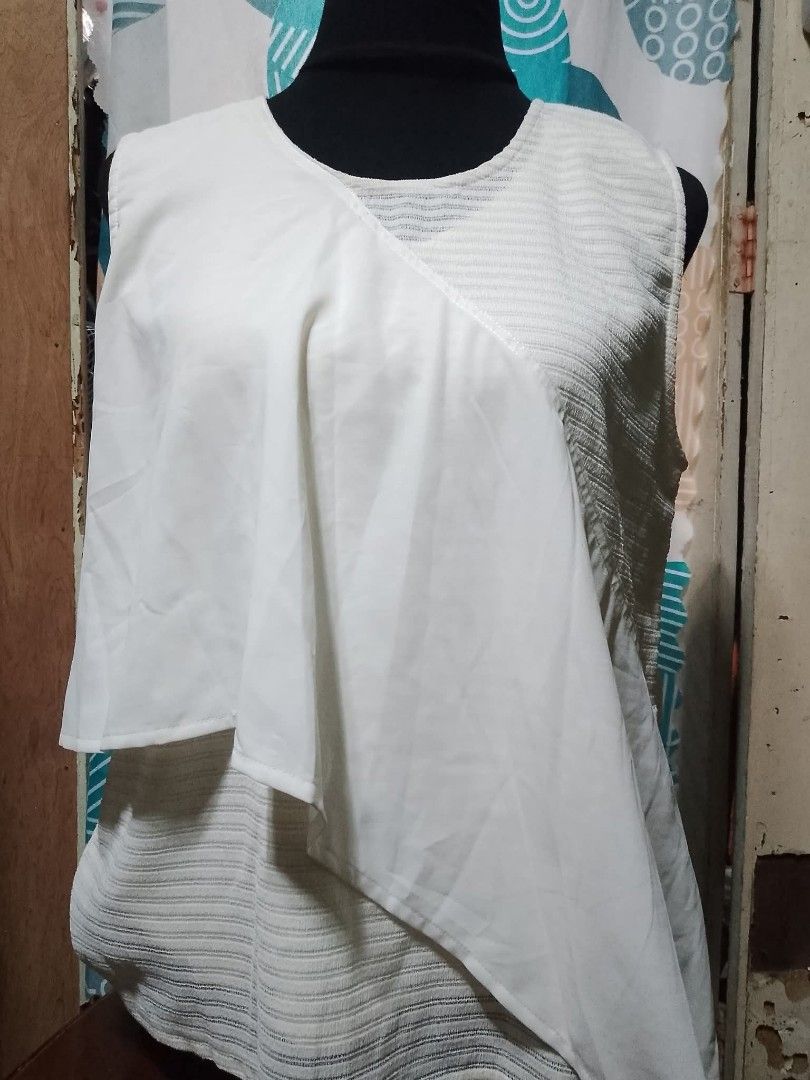 White Sleeveless Asymmetrical Overlay Top (Category: Sleeveless) located in Batangas. Submitted by sheenx.09 (Listing ID 1460772164, Image 1). Description: - L on tag (L to XL) - White sleeveless top ♥️ - Textured fabric base 🫶 - Flowy asymmetrical overlay in the front - Unique and stylish design ☺️ - Comfortable for all-day wear - Perfect for dressing up or down.