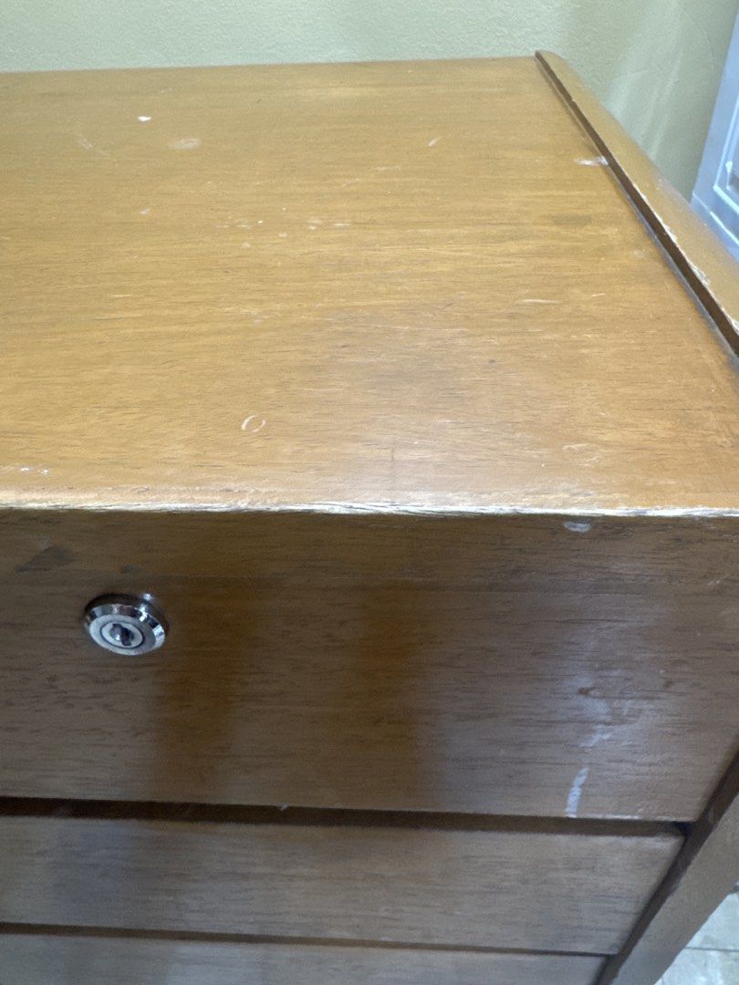 Wooden table with filing cabinet with lock (Category: Office Furniture & Fixtures) located in Manila. Submitted by cardiodiamond09 (Listing ID 1460862561, Image 1). Description: - Wooden filing cabinet - Four drawers total - Top drawer features a lock for added security - Natural wood grain visible - Minor surface marks present - Ideal for organizing documents and files.