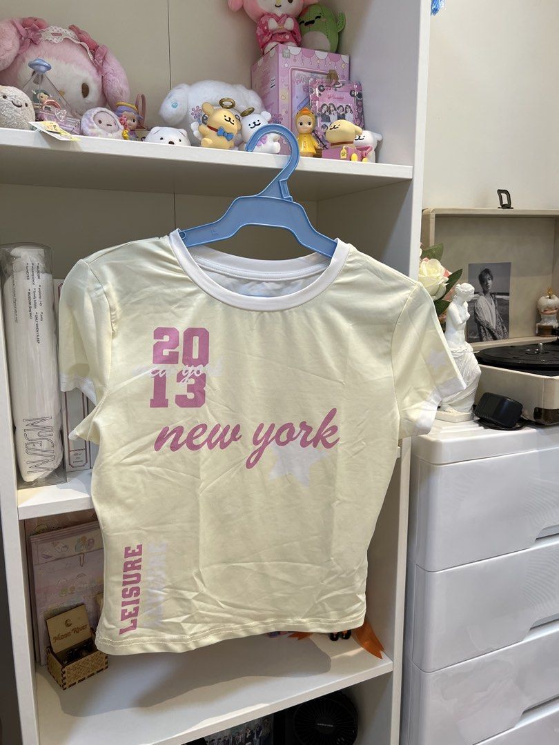 Yellow baby tee (Category: Shirts) located in Manila. Submitted by jinicarts (Listing ID 1460794835, Image 1). Description: - Adorable yellow t-shirt - Features '2013 New York' graphic - 'Leisure' text detail down the side - Short sleeves - White trim around the neckline - Ideal for a casual and stylish look.