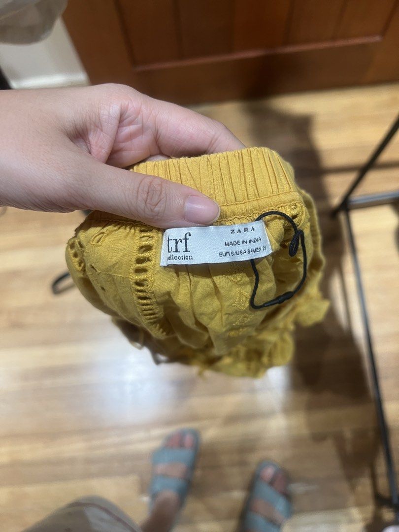 Zara TRF Yellow Eyelet Off-Shoulder Top (Category: Blouses) located in Quezon City. Submitted by iminquezoncity (Listing ID 1460809525, Image 2). Description: - Zara TRF yellow off-shoulder top - Eyelet details and tie-front neckline - Ruffled trim along neckline and sleeves - Lightweight and airy fabric - Ideal for warm weather - Versatile styling with shorts or jeans.