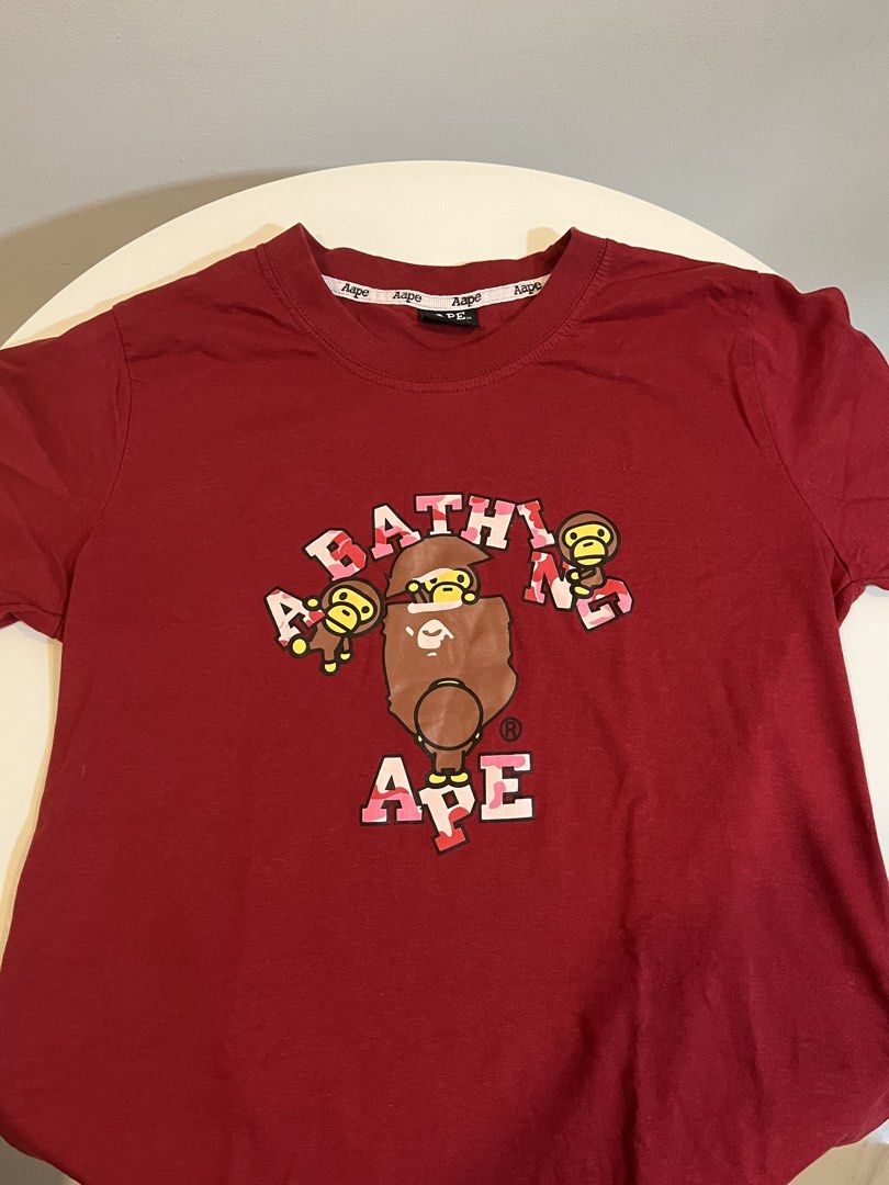 Aape by A Bathing Ape Red Monkey Print T-shirt (Category: Shirts) located in Manila. Submitted by xoshushi.dcltr (Listing ID 1460972153, Image 2). Description: - Features the classic Aape monkey graphic - Classic crew neck and short sleeve design - Ideal for casual and everyday wear - High-quality print details.