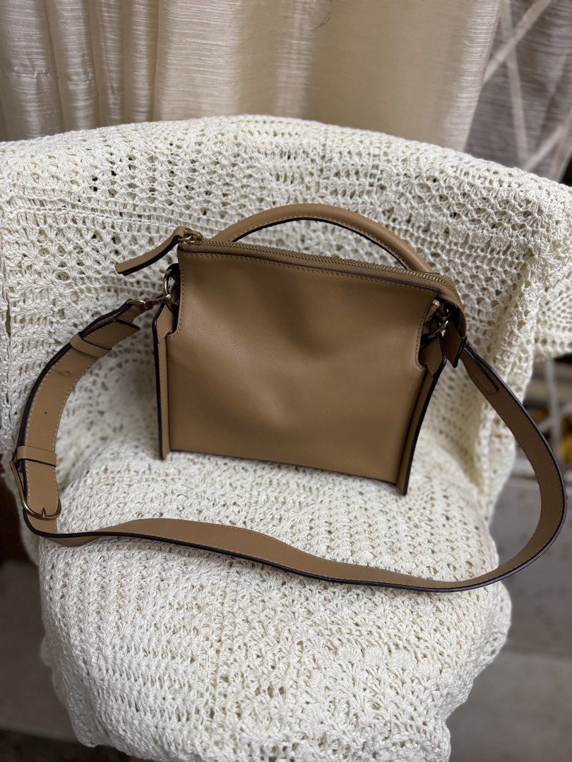 Accordion Top-Handle Bag (Category: Cross-body Bags) located in Bacolod City. Submitted by vintage_vogue6100 (Listing ID 1461073000, Image 1). Description: - Genuine tan leather crossbody bag - Versatile: can be carried by top handle or worn crossbody - Adjustable shoulder strap with buckle for a custom fit - Secure zipper closure - Chic stitching detail on bottom corners - Ideal everyday bag.