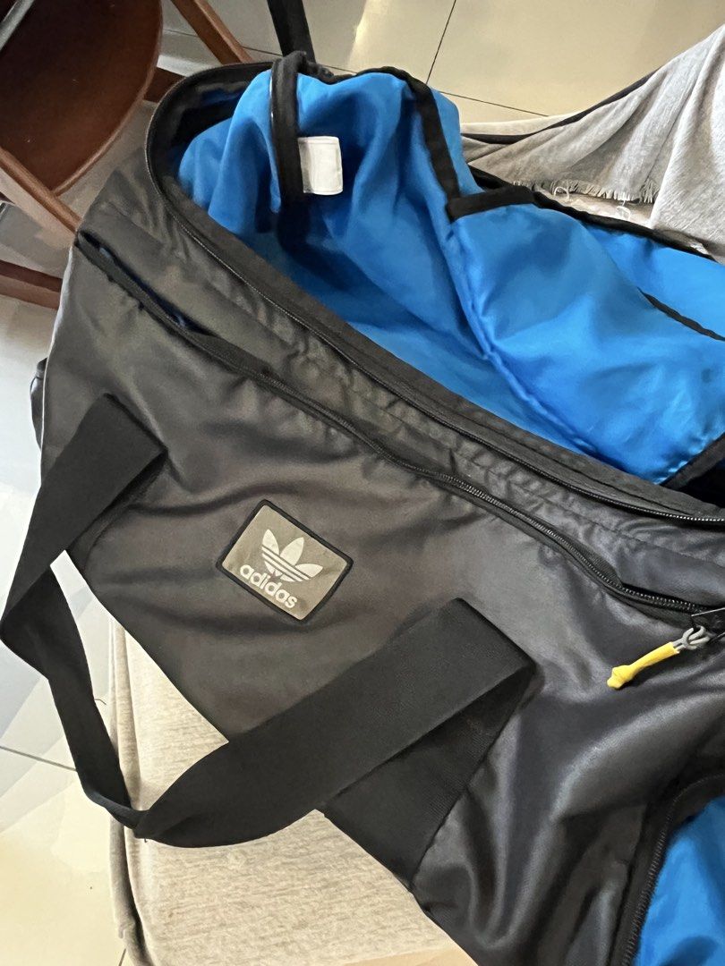 Adidas Black Duffel Bag (Category: Backpacks) located in Manila. Submitted by momfinds.mnl (Listing ID 1460931224, Image 2). Description: - Black Adidas duffel bag - Bright blue interior - Main compartment with zippered closure - Interior mesh pocket with zipper - Durable material - Ideal for gym or travel - Needs wash.