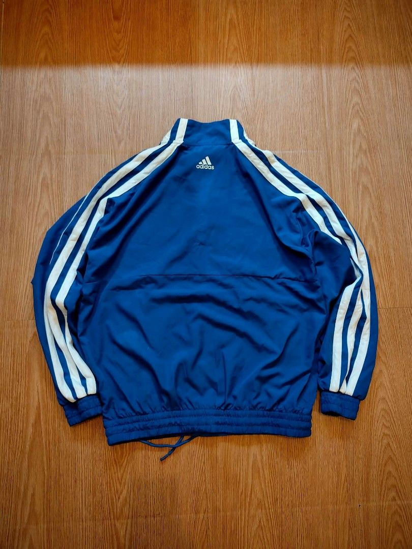 Adidas Blue Track Jacket with White Stripes (Category: Coats, Jackets and Outerwear) located in Muntinlupa City. Submitted by thegoodthriftph (Listing ID 1460940664, Image 3). Description: - Classic blue Adidas track jacket - Iconic white three stripes on sleeves - Half-zip closure with stand-up collar - Elasticated cuffs and hem with drawstring - Small embroidered Adidas logo on front - Ideal for casual wear or sports activities.