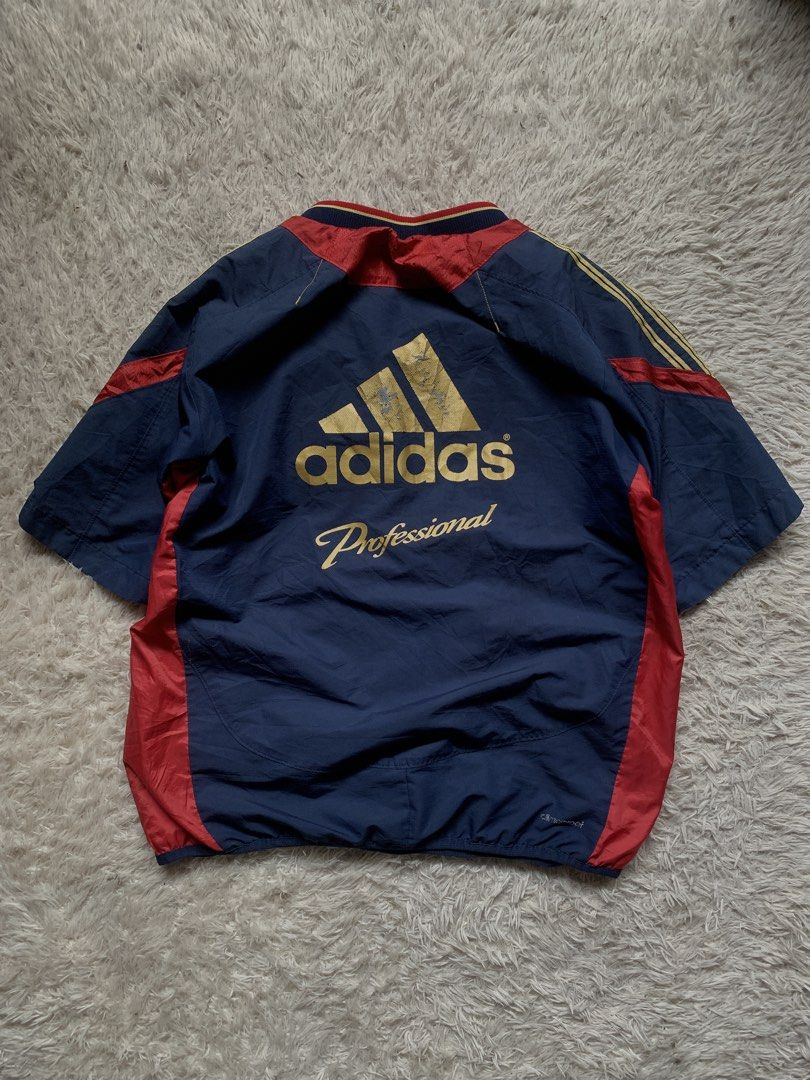 Adidas Professional Windbreaker Jacket (Category: Coats, Jackets and Outerwear) located in General Santos City (Dadiangas). Submitted by thrifty_gsc (Listing ID 1461017092, Image 1). Description: - Vintage Adidas Professional jacket - Color: Navy blue with red and yellow accents - Features: Short sleeves, elasticated hem - Design: Classic Adidas stripes on sleeves, large Adidas Professional logo on back - Ideal for: Casual wear or sports.