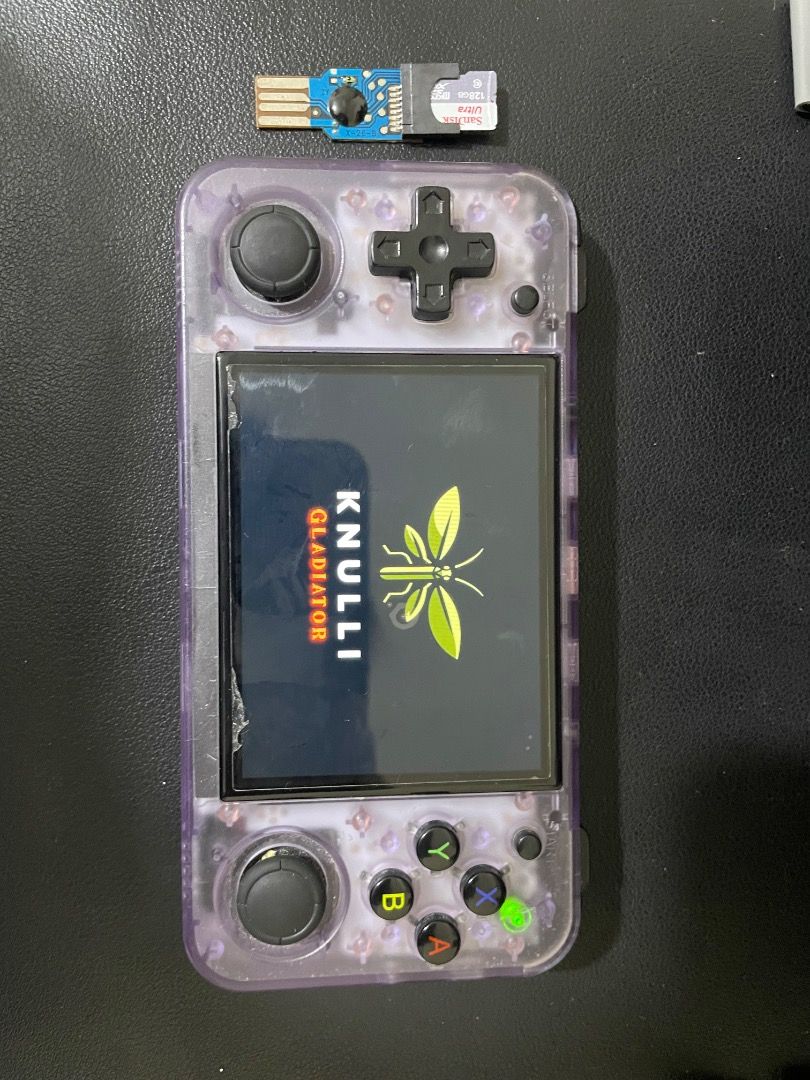 Anbernic RG 35XXH (Category: Cases & Sleeves) located in Caloocan City. Submitted by pure.kailix011523 (Listing ID 1461087580, Image 3). Description: - Brand: Anbernic - Model: RG35XXH - Type: Handheld Retro Gaming Console - Design: Transparent casing, allowing view of internal components - Included Accessories: USB adapter (SIM card slot visible ISSUE: Right Button 1 Cant be clicked Back Rubber is gone INCLUSIONS 32GB SD CARD (Knulli OS) 128GB S