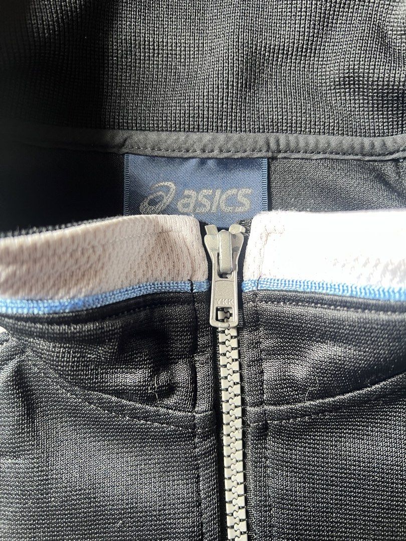 Asics Track Jacket (Category: Coats, Jackets and Outerwear) located in Borongan. Submitted by thriftsbyblas (Listing ID 1460932461, Image 3). Description: - Classic Asics track jacket - Color: Black with white and light blue sleeve/collar accents - Full zip front with pockets - Features a durable YKK zipper - Ideal for sports or casual wear.