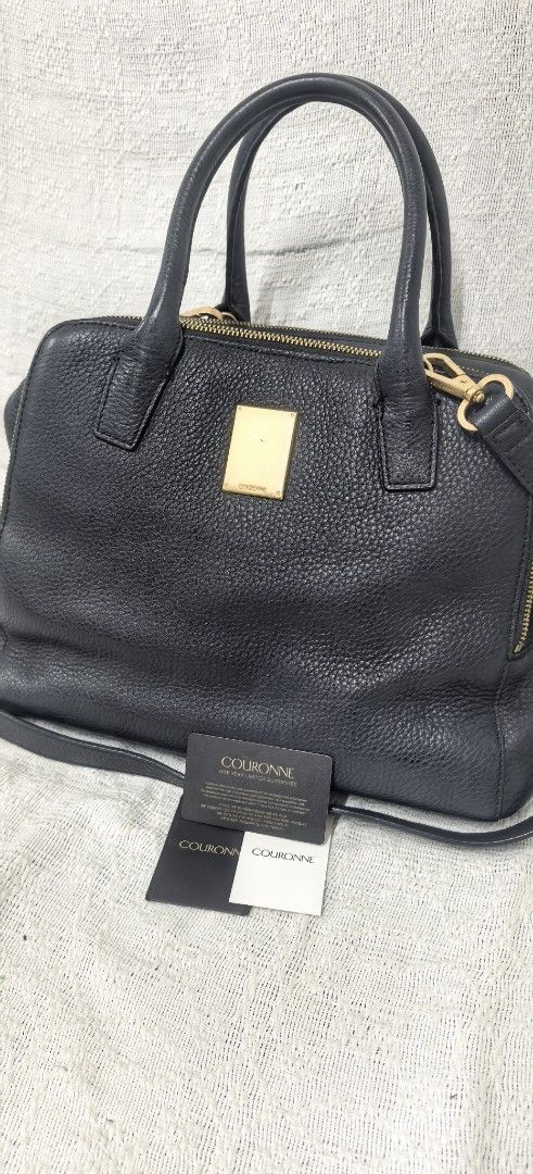 Authentic Couronne Bag (Category: Cross-body Bags) located in Quezon City. Submitted by arwenpasion (Listing ID 1461027536, Image 1). Description: - Brand: Couronne - Material: Genuine Black Leather, thick leather. Very durable - Very roomy with 3 compartments -See measurement at the photo - Hardware: Gold - Closure: Top Zip - Strap: Detachable shoulder strap included - Authenticity: Comes with authenticity cards - Versatility: Great for everyday