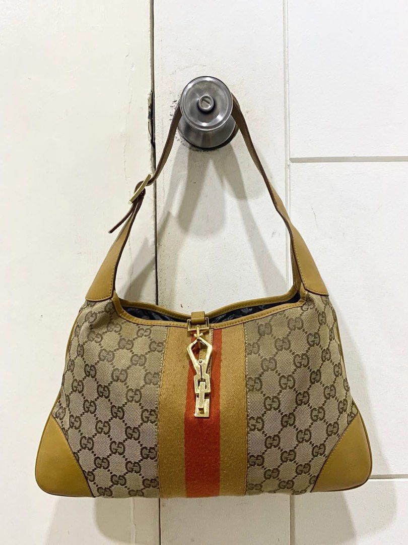 Authentic Gucci Jackie Beige Monogram Canvas with Red Stripe (Category: Luxury Bags & Wallets) located in Angeles City. Submitted by graiqs (Listing ID 1460997040, Image 1). Description: - Authentic Gucci shoulder bag - Classic GG monogram canvas - Tan leather trim - Red and beige stripe detail - Gold-tone hardware with Gucci logo clasp - Single shoulder strap - Clean interior - Stylish everyday bag - with COA - PRICE IS FIXED.