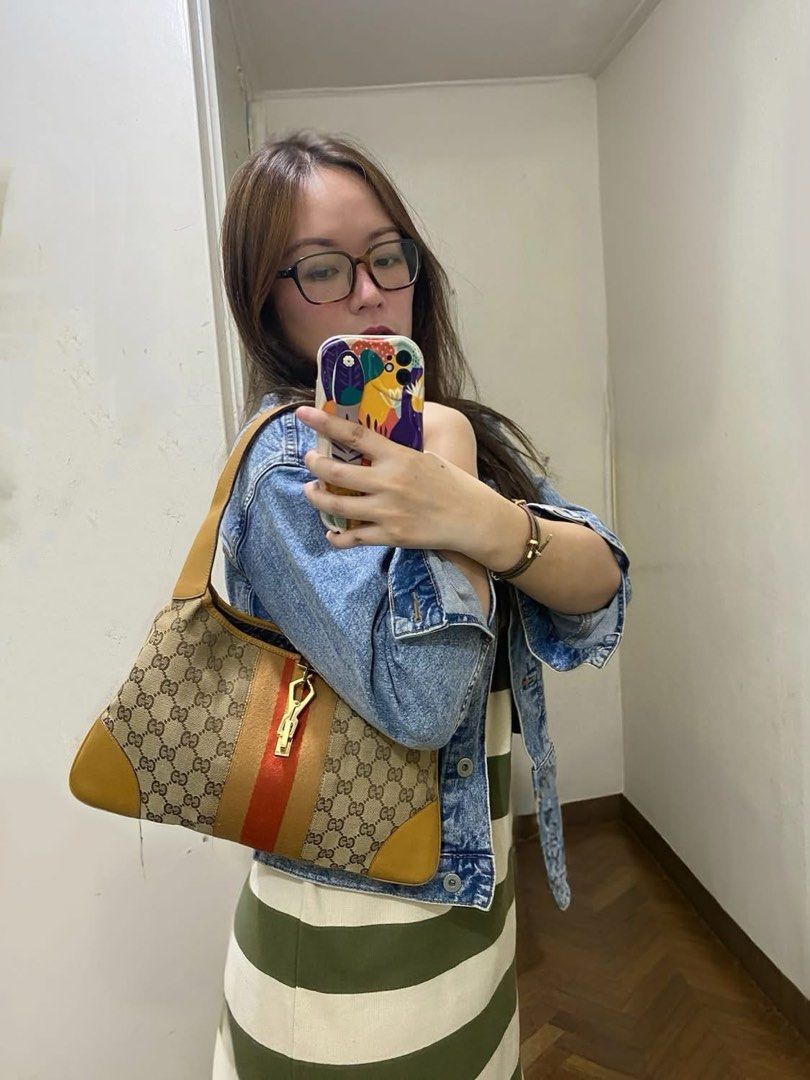 Authentic Gucci Jackie Beige Monogram Canvas with Red Stripe (Category: Luxury Bags & Wallets) located in Angeles City. Submitted by graiqs (Listing ID 1460997040, Image 2). Description: - Authentic Gucci shoulder bag - Classic GG monogram canvas - Tan leather trim - Red and beige stripe detail - Gold-tone hardware with Gucci logo clasp - Single shoulder strap - Clean interior - Stylish everyday bag - with COA - PRICE IS FIXED.