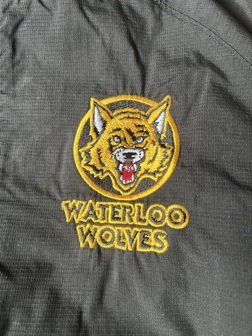 Bauer Waterloo Wolves Hockey Track Jacket (Category: Coats, Jackets and Outerwear) located in Borongan. Submitted by thriftsbyblas (Listing ID 1460932536, Image 2). Description: - Black Bauer track jacket - Features embroidered Waterloo Wolves logo - White piping detail along the sides - Full zip front with Bauer branded zipper pull - Size: M/M - Perfect for any fan!.