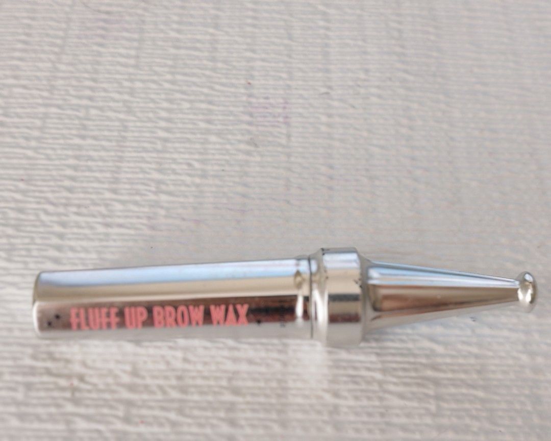 Benefit Cosmetics Fluff Up Brow Wax (Category: Makeup) located in Manila. Submitted by itsmejorgy14 (Listing ID 1460941594, Image 1). Description: - Benefit Cosmetics Fluff Up Brow Wax - Shapes and sets eyebrows - Achieves a fluffy brow look - Features silver packaging with pink lettering.