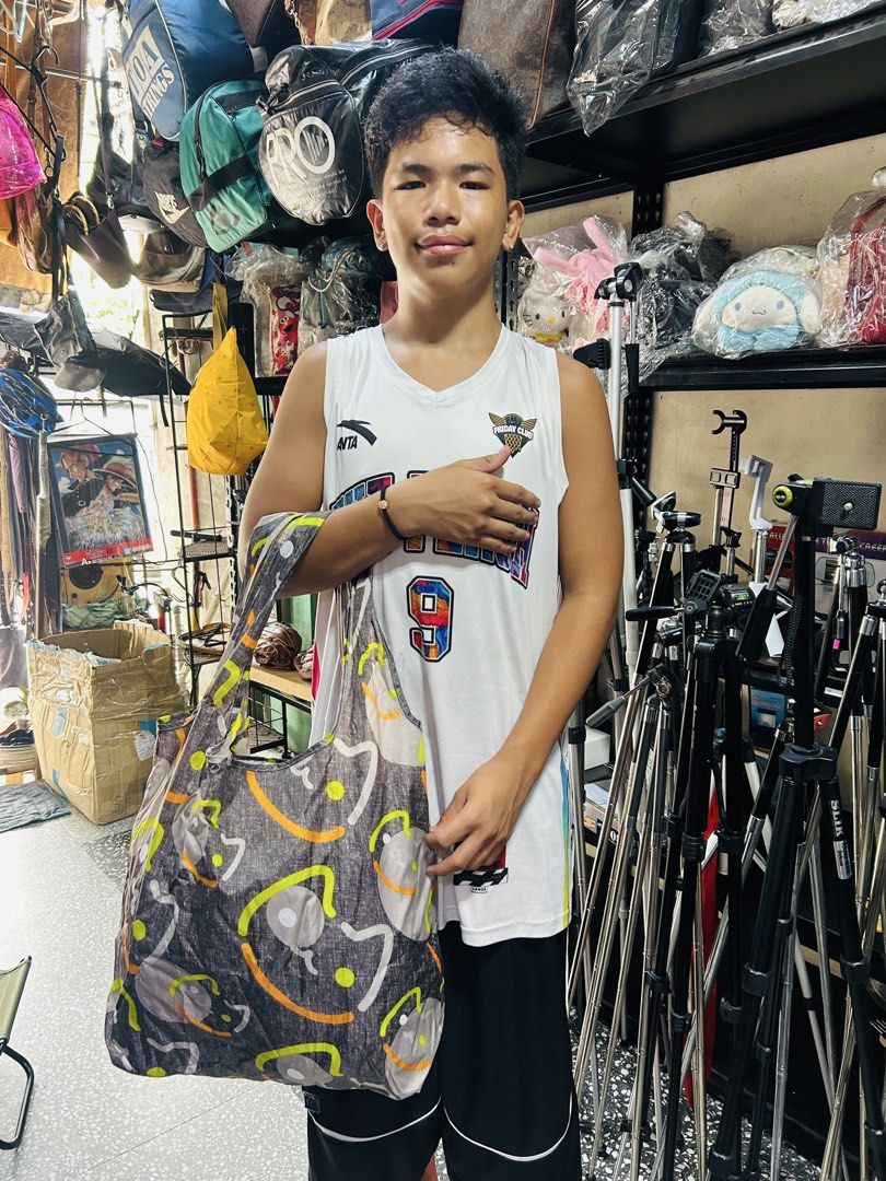 BIGHA'S Reusable Foldable Tote Bag (Category: Tote Bags) located in Manila. Submitted by starbalesukandjapansurplus (Listing ID 1460928806, Image 2). Description: - Cute and foldable tote bag from BIGHA'S - Ideal for groceries or everyday use - Folds up small to fit easily in your purse - Features a fun pattern with cartoon faces and colorful accents - Easy to carry and store.