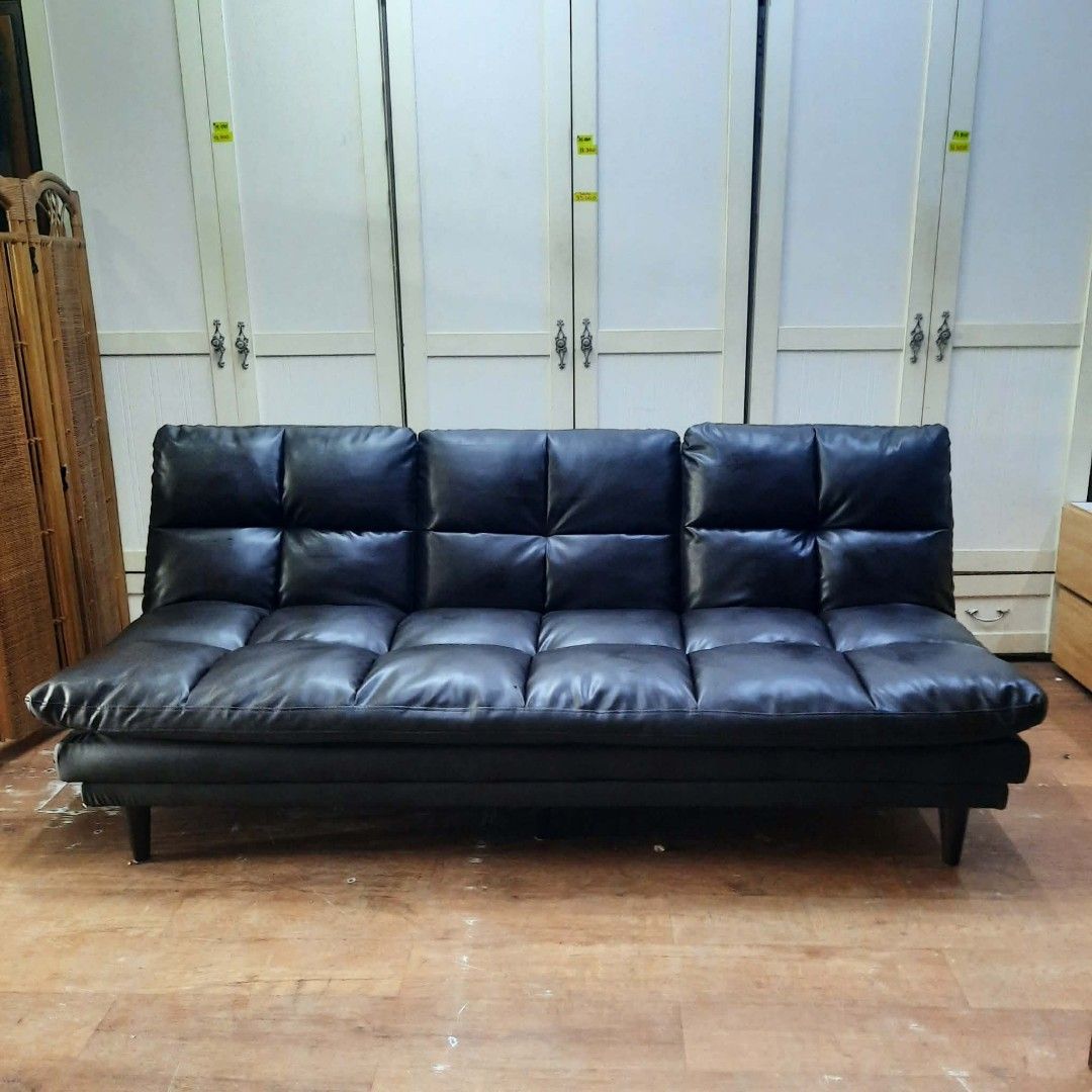 Black Faux Leather Sofa Bed with Built-in Table (Category: Sofas) located in Manila. Submitted by ivan_furnitures421 (Listing ID 1460926737, Image 3). Description: - Black faux leather sofa bed - Folds out into a flat bed - Middle section converts to a table or armrest - Tufted cushion design - Ideal for small spaces - Easy to convert between sofa and bed - Short and sturdy legs.