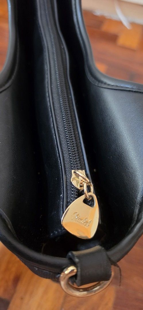 Black "Kimbel" Handbag with Shoulder Strap (Category: Luxury Bags & Wallets) located in Caloocan City. Submitted by echoes_of_nnah (Listing ID 1461011896, Image 3). Description: - Stylish black Nimbel handbag - Textured exterior with embossed logo - Gold hardware details - Cute heart-shaped zipper pull - Detachable shoulder strap for versatility - Interior zippered compartment - Clean interior - Ideal everyday bag.
