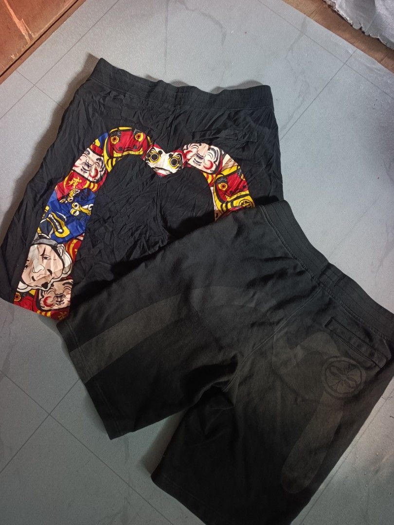 Black Shorts with Daruma Doll Print (Category: Shorts) located in Manila. Submitted by charlesthrifted (Listing ID 1460940521, Image 1). Description: - Two pairs of black shorts included. - First pair features a cool Daruma doll graphic on one leg. - Second pair is plain black with subtle grey stripes. - Second pair has a circular logo on the back pocket. - Both pairs have comfortable elastic waistbands. - Ideal for casual outings or relaxing at 
