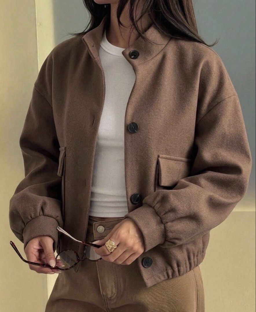 Brown Bomber Jacket with Button Closure (Category: Coats, Jackets and Outerwear) located in Iloilo. Submitted by dabyladaby2 (Listing ID 1461051476, Image 1). Description: - Super cute brown bomber jacket - Features a nice collar and button-up front - Convenient front pockets - Elasticated cuffs and hem for a snug fit - Versatile for pairing with jeans or trousers - Ideal for a stylish casual look - shoulder- 21.7 in, bust 42.5 in, length -21.3in