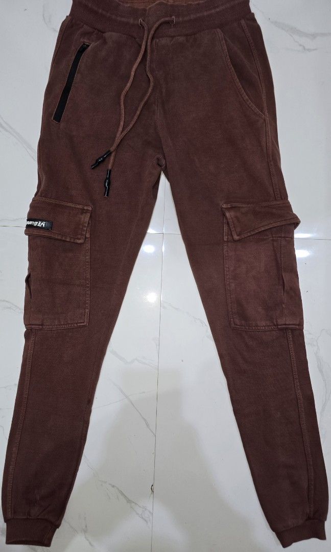 Brown Cargo Jogger Pants with Zip Pocket (Category: Joggers) located in La Trinidad. Submitted by odin21 (Listing ID 1460953511, Image 1). Description: - Stylish brown cargo jogger pants - Comfortable elastic waistband with adjustable drawstring - Convenient side pockets - Functional cargo pockets on both legs, one with a 'Future LA' tag - Secure zip pocket on the left thigh - Ribbed cuffs for a modern, tapered look small on tag.