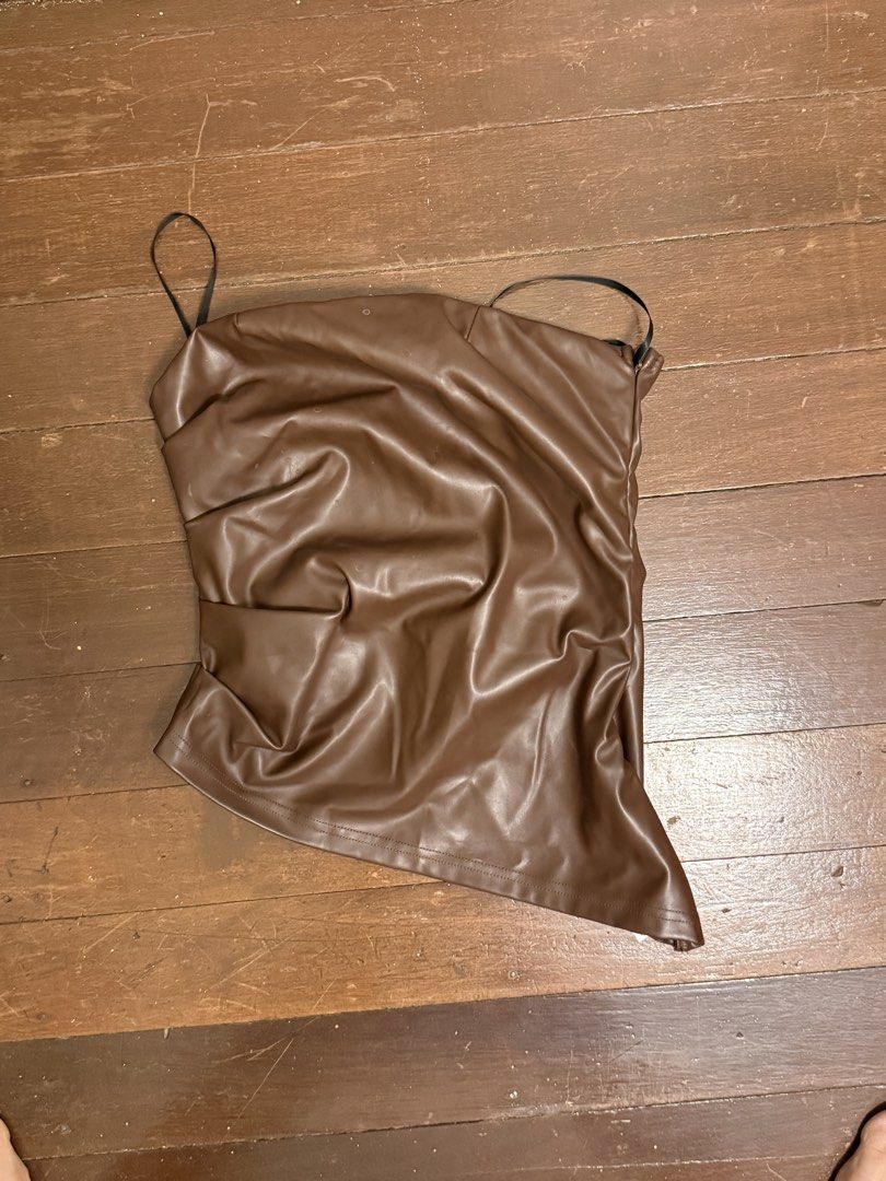 Brown Ruched Faux Leather Strapless Top (Category: Sleeveless) located in Angeles City. Submitted by lesmiz24601 (Listing ID 1460976056, Image 2). Description: - Brown strapless top - Ruched detailing - Faux leather material - Side zipper closure - Thin black straps - Estimated size: Small to Medium - Ideal for night outs or parties - Versatile: pair with jeans or a skirt.