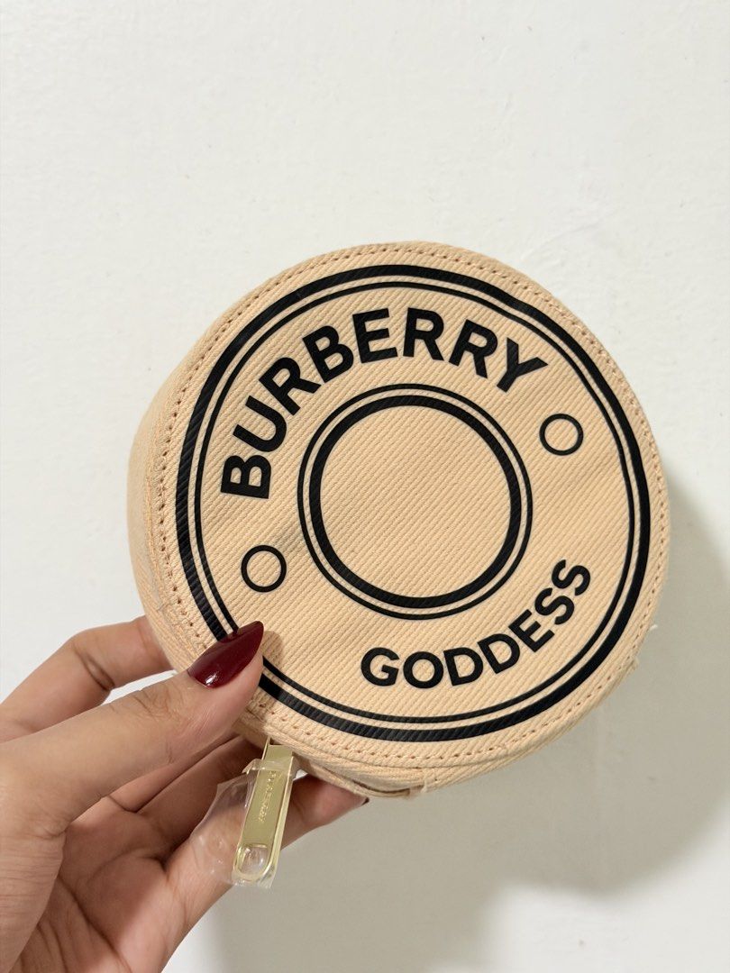 Burberry Goddess Round Pouch (Category: Purses & Pouches) located in Manila. Submitted by jultrinx (Listing ID 1461107559, Image 1). Description: - Authentic Burberry round coin pouch. - Features the iconic 'Burberry Goddess' print. - Secure zip closure with a branded gold-tone zipper pull. - Interior strap with a snap button for added organization. - Ideal for coins, cards, or other small essentials..