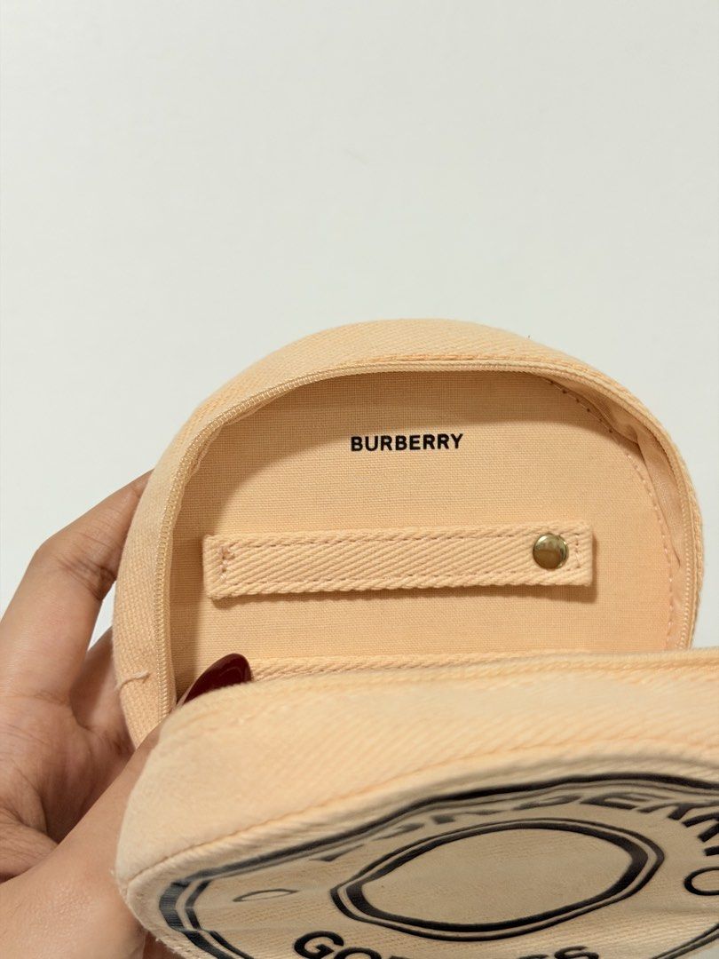 Burberry Goddess Round Pouch (Category: Purses & Pouches) located in Manila. Submitted by jultrinx (Listing ID 1461107559, Image 2). Description: - Authentic Burberry round coin pouch. - Features the iconic 'Burberry Goddess' print. - Secure zip closure with a branded gold-tone zipper pull. - Interior strap with a snap button for added organization. - Ideal for coins, cards, or other small essentials..