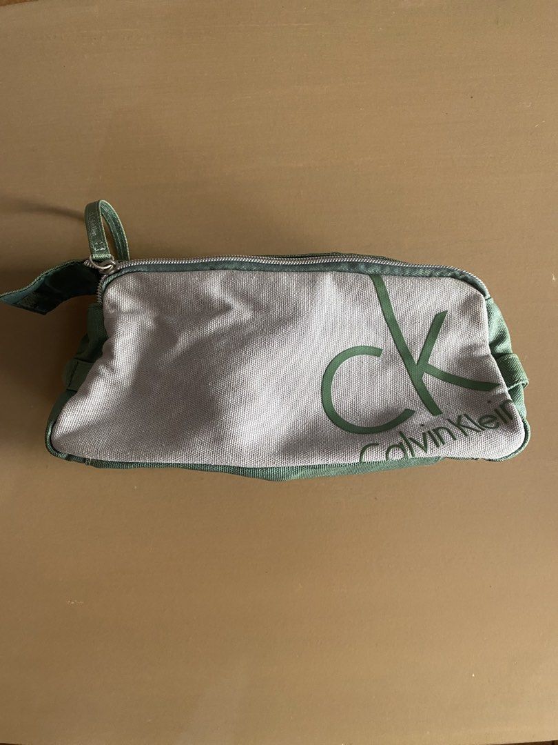 Calvin Klein CK Pouch Bag Green Grey (Category: Purses & Pouches) located in Baguio. Submitted by arenzu (Listing ID 1460949826, Image 1). Description: - Authentic Calvin Klein pouch - Color: Grey and Green - Features iconic CK logo print on the front - Secure zipper closure - Green fabric bottom - Interior has a small velcro pocket - Ideal for storing makeup, toiletries, or other small essentials.