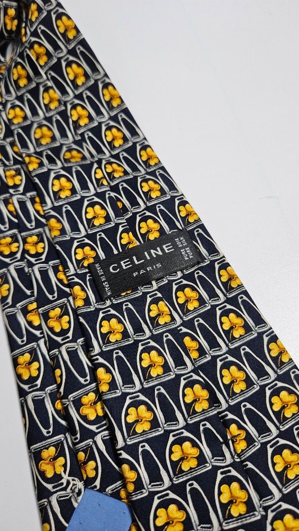 Celine Paris Pure Silk Tie - Made in Spain (Category: Ties) located in Alfonso. Submitted by jbcamet (Listing ID 1461041339, Image 2). Description: - Navy blue 100% pure silk tie - Features a repeating pattern of yellow clovers inside white horseshoe shapes - Crafted in Spain - Adds a pop of color and sophistication to any formal outfit.