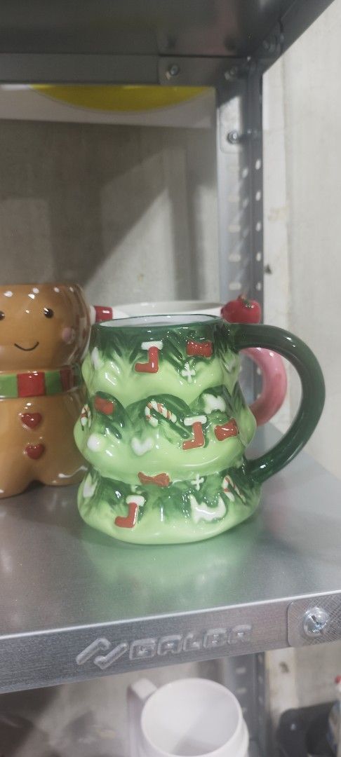 Christmas Tree Mug with Candy Cane and Stocking Design (Category: Other Home Decor) located in Manila. Submitted by silverwhale_cafa21 (Listing ID 1461039648, Image 1). Description: - Adorable Christmas tree mug design - Features candy canes and little stockings all over - Dark green handle with a pink accent - Perfect for hot cocoa or coffee during the holidays - Great for gifting or personal festive collection.