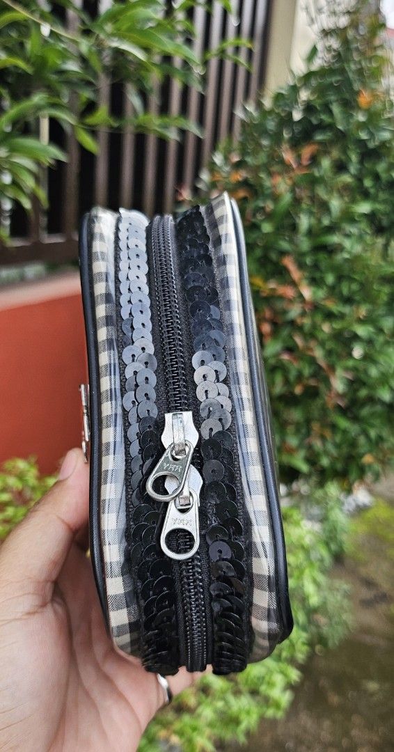 Clear Cosmetic Bag with Plaid and Sequins (Category: Purses & Pouches) located in Cavite. Submitted by sunghanphil_31 (Listing ID 1461087791, Image 2). Description: - Cute clear cosmetic bag - Black and white plaid pattern on sides - Black sequins detailing around the zipper - Zipper closure for secure storage - Features a small metal emblem on the front - Ideal for organizing makeup, toiletries, or other small essentials.