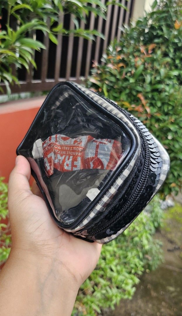 Clear Cosmetic Bag with Plaid and Sequins (Category: Purses & Pouches) located in Cavite. Submitted by sunghanphil_31 (Listing ID 1461087791, Image 3). Description: - Cute clear cosmetic bag - Black and white plaid pattern on sides - Black sequins detailing around the zipper - Zipper closure for secure storage - Features a small metal emblem on the front - Ideal for organizing makeup, toiletries, or other small essentials.
