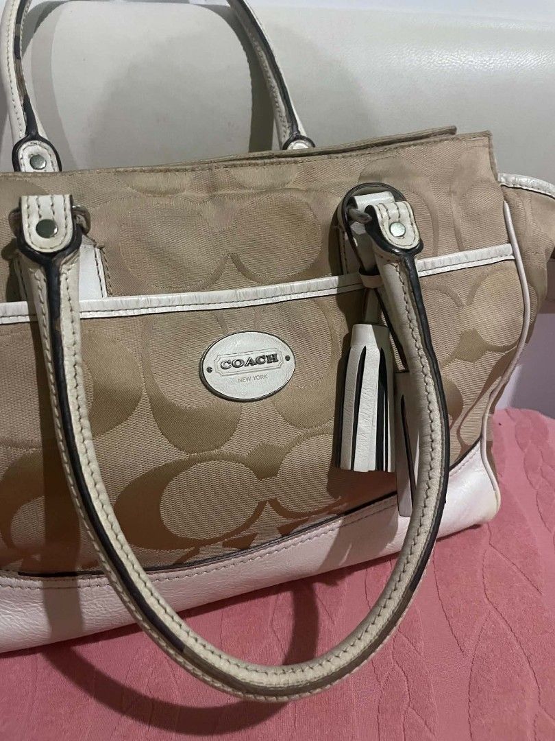 Coach Monogram Canvas Leather Trimmed Handbag (Category: Luxury Bags & Wallets) located in Legazpi City. Submitted by treasurebonbon (Listing ID 1461032560, Image 3). Description: - Classic Coach monogram canvas handbag - White leather trim and handles - Two decorative tassels on the front - Secure zipper closure at the top - Protective metal studs on the bottom - Ideal stylish everyday bag This item is in good condition, there is some general we