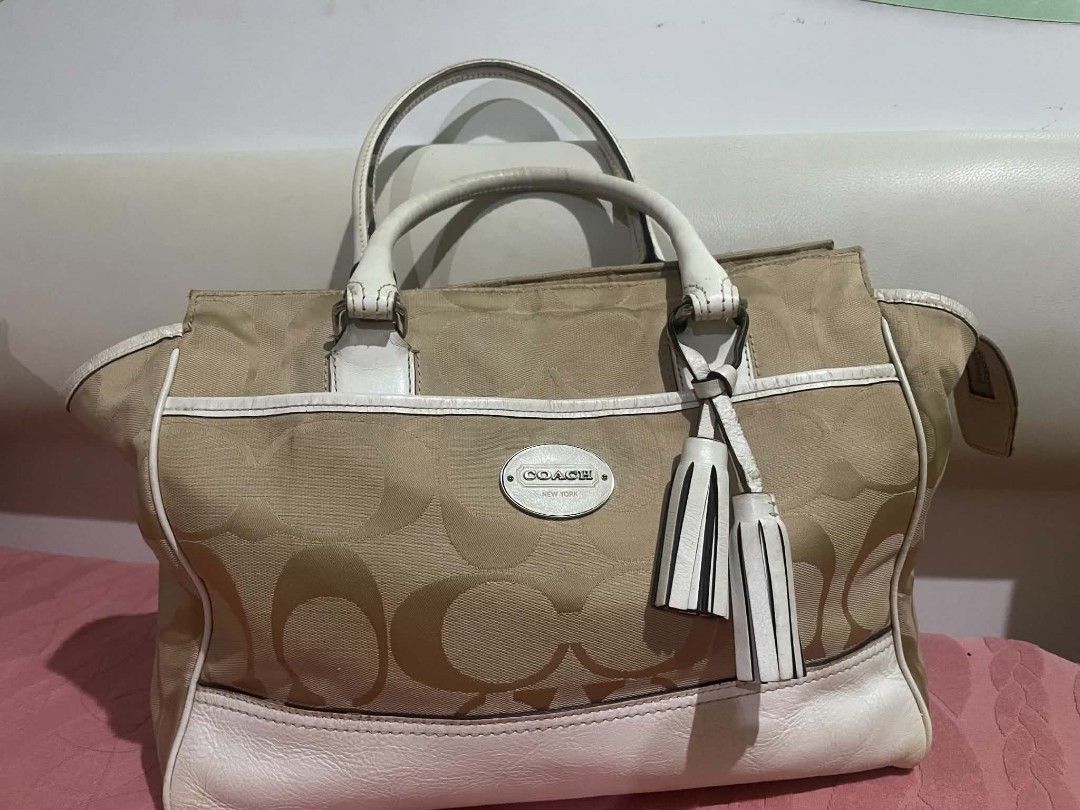 Coach Monogram Canvas Leather Trimmed Handbag (Category: Luxury Bags & Wallets) located in Legazpi City. Submitted by treasurebonbon (Listing ID 1461032560, Image 1). Description: - Classic Coach monogram canvas handbag - White leather trim and handles - Two decorative tassels on the front - Secure zipper closure at the top - Protective metal studs on the bottom - Ideal stylish everyday bag This item is in good condition, there is some general we