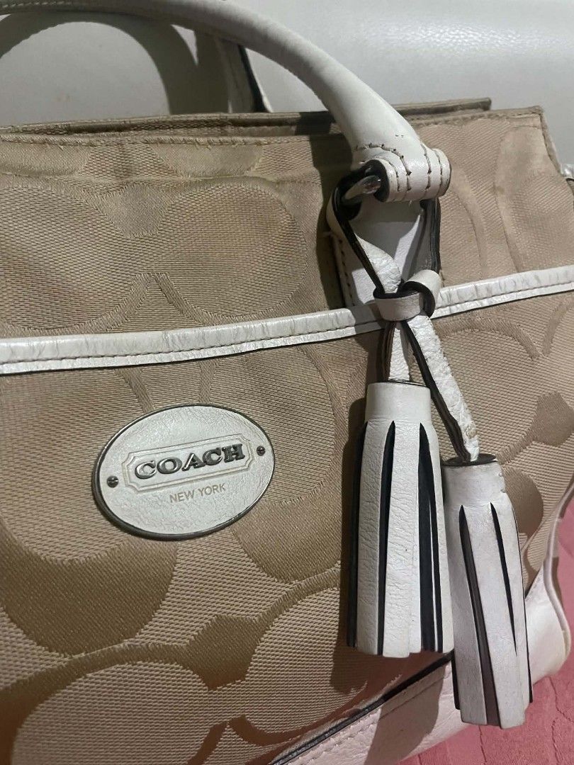 Coach Monogram Canvas Leather Trimmed Handbag (Category: Luxury Bags & Wallets) located in Legazpi City. Submitted by treasurebonbon (Listing ID 1461032560, Image 2). Description: - Classic Coach monogram canvas handbag - White leather trim and handles - Two decorative tassels on the front - Secure zipper closure at the top - Protective metal studs on the bottom - Ideal stylish everyday bag This item is in good condition, there is some general we