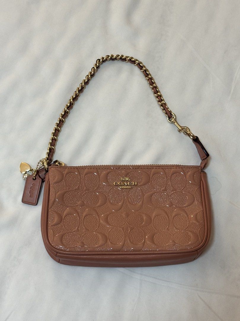 Coach Monogram Embossed Patent Leather Wristlet Pouch Bag (Category: Luxury Bags & Wallets) located in Manila. Submitted by khatalogue (Listing ID 1460992338, Image 1). Description: - 2-in-1 Dusty rose Coach wristlet or shoulder bag - Patent leather with all-over signature monogram embossing - Gold chain strap and hardware - Includes Coach hangtag and heart charm - Zipper closure - Lined interior - Ideal for carrying essentials.