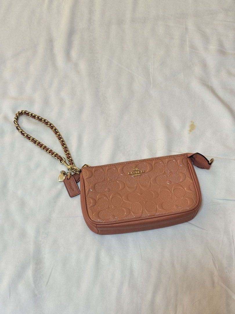 Coach Monogram Embossed Patent Leather Wristlet Pouch Bag (Category: Luxury Bags & Wallets) located in Manila. Submitted by khatalogue (Listing ID 1460992338, Image 3). Description: - 2-in-1 Dusty rose Coach wristlet or shoulder bag - Patent leather with all-over signature monogram embossing - Gold chain strap and hardware - Includes Coach hangtag and heart charm - Zipper closure - Lined interior - Ideal for carrying essentials.