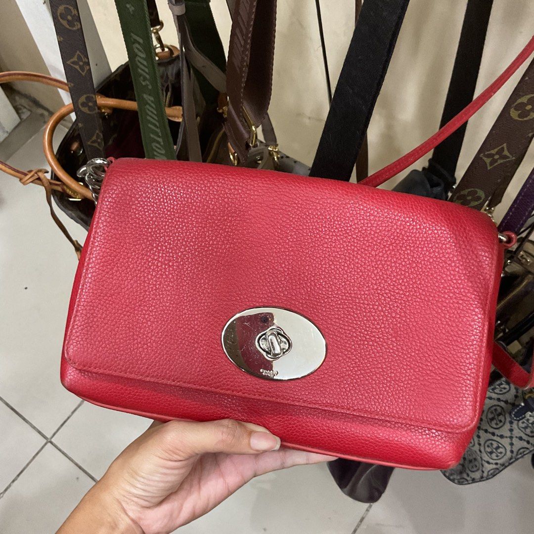 Coach Red Leather Turnlock Crossbody Bag (Category: Luxury Bags & Wallets) located in Manila. Submitted by asianbellahadidd (Listing ID 1461033591, Image 1). Description: - Authentic Coach red leather crossbody bag - Secure turnlock closure on the front - Interior features multiple slip pockets - Signature Coach logo pattern lining - Sleek silver hardware - Ideal for everyday wear and errands.