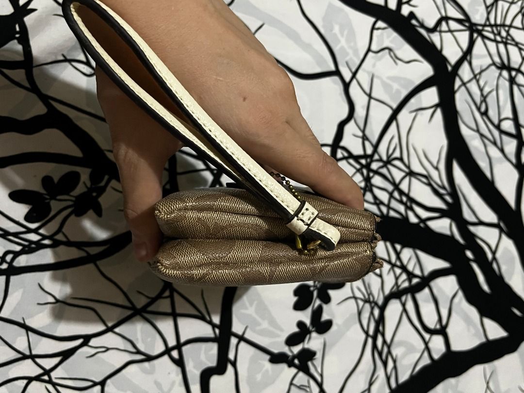 Coach Signature Double Zip Wristlet Pouch (Category: Luxury Bags & Wallets) located in Infanta. Submitted by izzy2shop (Listing ID 1461113377, Image 2). Description: - Coach wristlet pouch - Signature C pattern - Two zippered compartments - Gold hardware - Detachable wrist strap - Ideal for cards, cash, and phone - Compact and easy to carry.